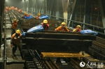 凌晨时分，南铁南昌工务段工人冒雨在赣江铁路大桥进行更换桥枕作业。 - 人民网